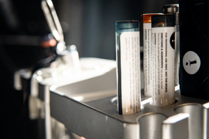 Zbliżenie na kilka jednorazowych zapalniczek stojących pionowo w uchwycie, światło słoneczne oświetla ich półprzezroczyste korpusy - podobnie jak precyzja i szczegóły widoczne w medycyna estetyczna Wrocław zabiegi takie jak botoks Wrocław.