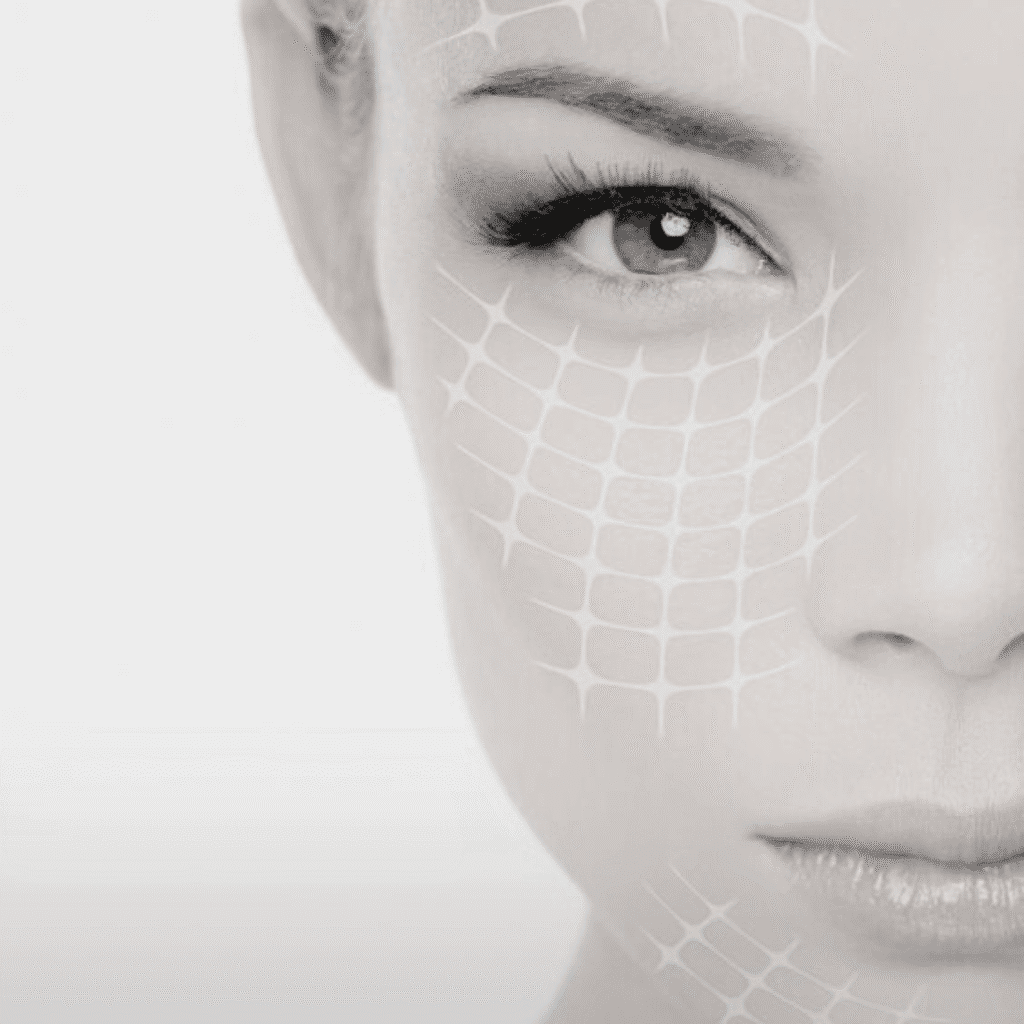 A close-up of a woman's face in black and white, with a grid-like pattern overlay, evokes themes of beauty and skincare—perfect for a klinika medycyny estetycznej or those interested in medycyna estetyczna Wrocław. Only one eye and half her face are visible.